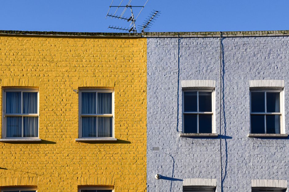Yellow and blue painted house fronts side by side.